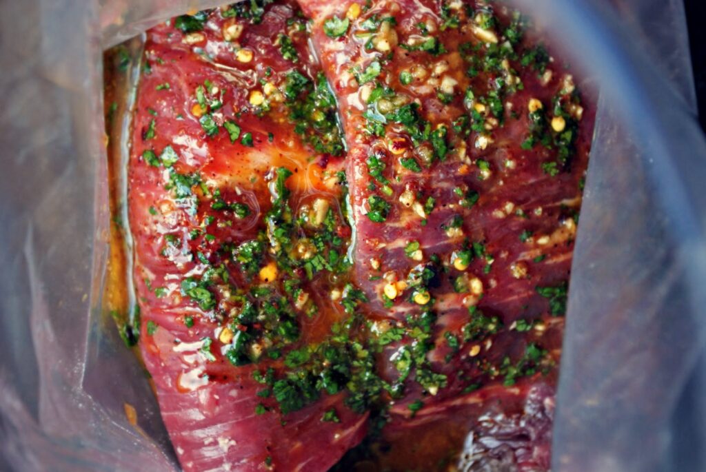 Marinated steak seasoned with herbs and spices in a vacuum-sealed bag. Ideal for grilling or roasting.