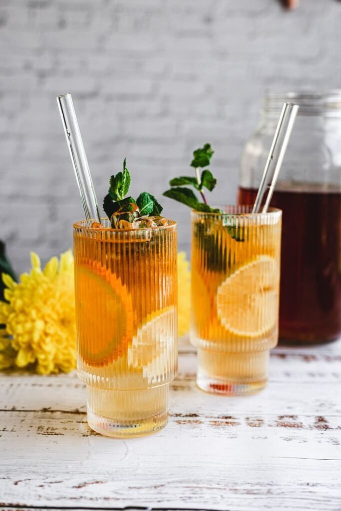 Two refreshing iced tea glasses with lemon slices and mint, ideal for summer enjoyment.