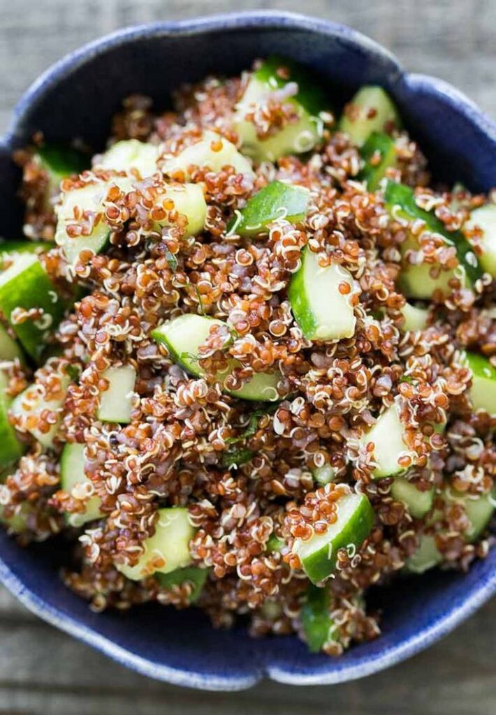 Red quinoa cucumber salad in a blue bowl, healthy and refreshing vegetarian dish.