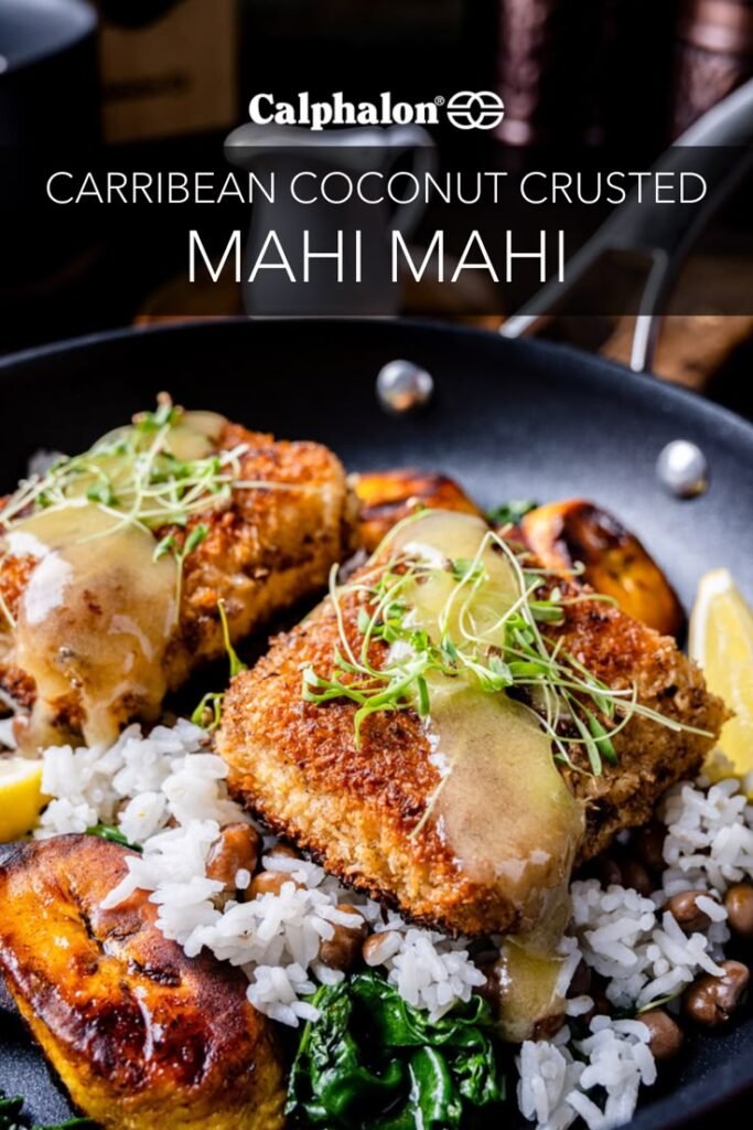 Caribbean coconut-crusted mahi-mahi with rice, plantains, and greens in a skillet, garnished with microgreens.