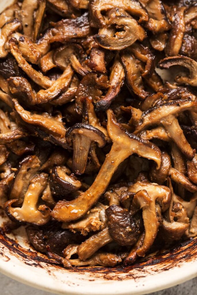 Roasted mushrooms with a golden-brown finish, showcasing rich, savory textures in a delicious side dish.