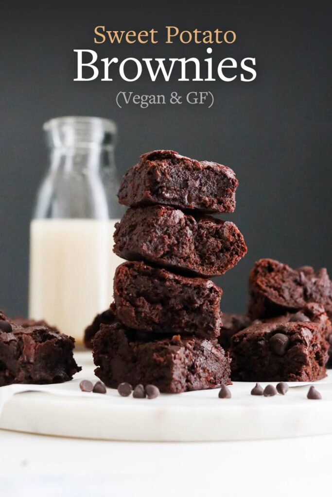 Vegan gluten-free sweet potato brownies stacked with chocolate chips, with a milk bottle in the background.