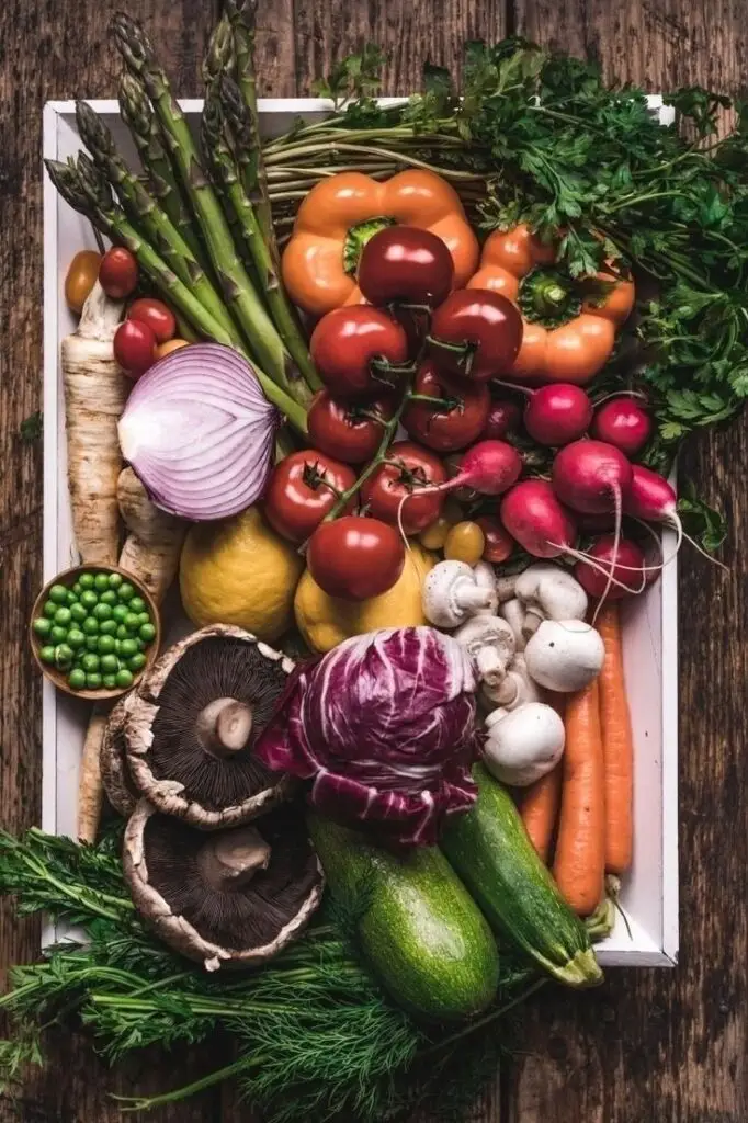Fresh vegetables assortment: tomatoes, peppers, radishes, mushrooms, zucchini, asparagus, perfect for healthy cooking.