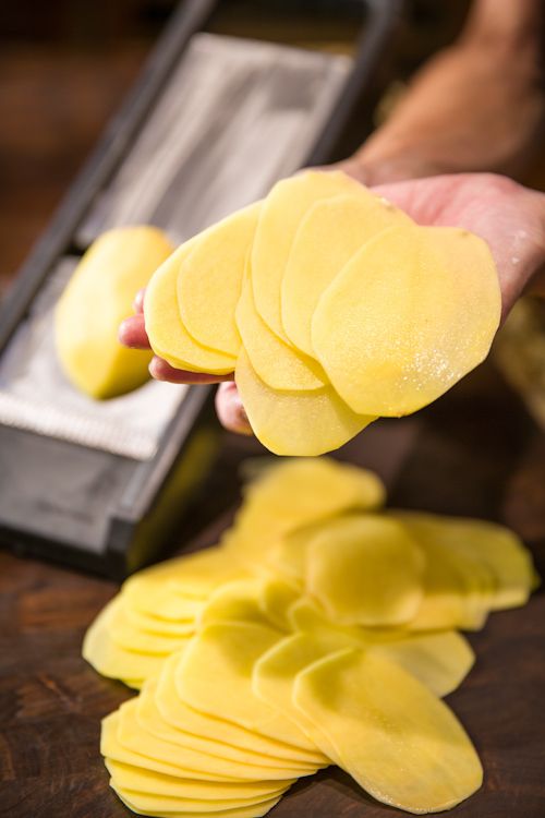 Thinly sliced potatoes prepared with a mandoline slicer, perfect for homemade chips or gratins.