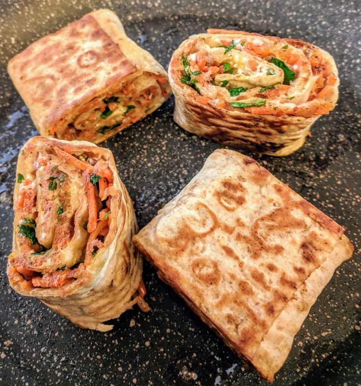 Grilled wrap slices on a skillet with carrots, greens, and cheese, perfect for a savory, healthy meal.