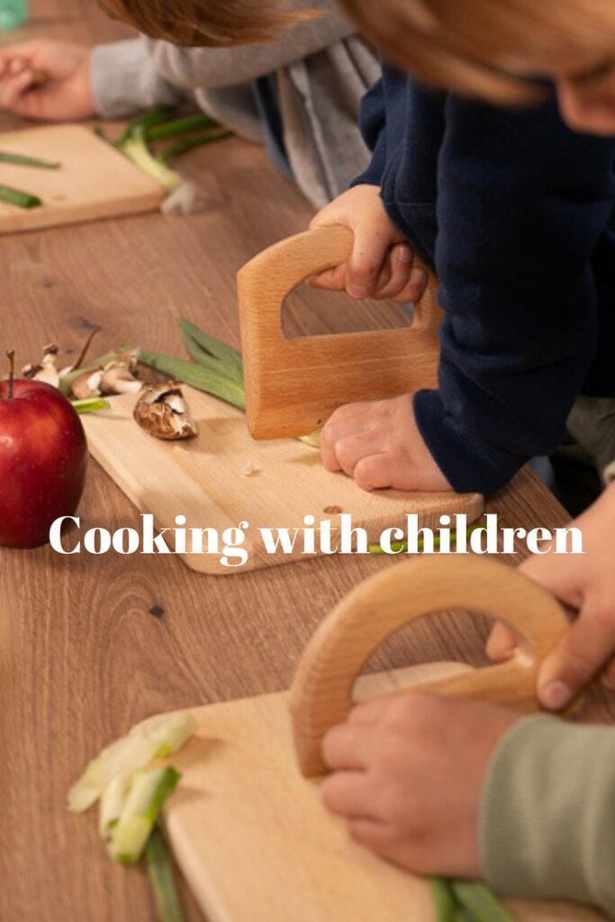 Children using safe knives to chop vegetables on wooden cutting boards in a cooking class.
