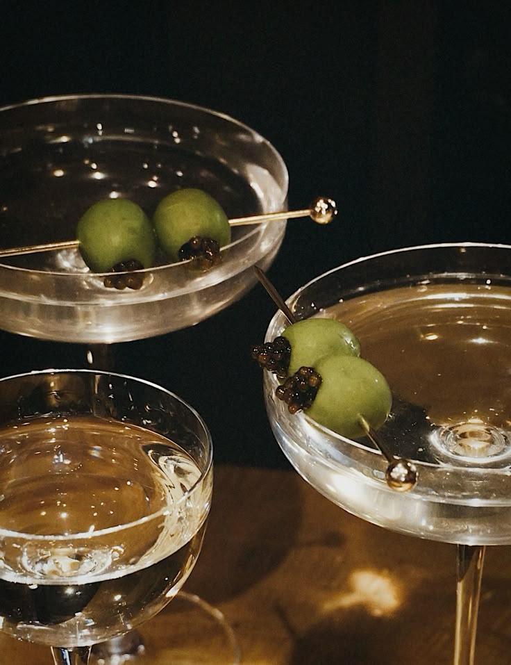 Elegant martini glasses with olives and caviar garnish, perfect for a luxurious cocktail setting.