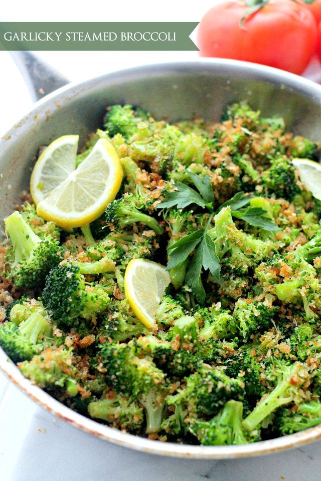 Garlicky steamed broccoli with lemon and parsley in a skillet, garnished with tomato. Healthy and delicious side dish.