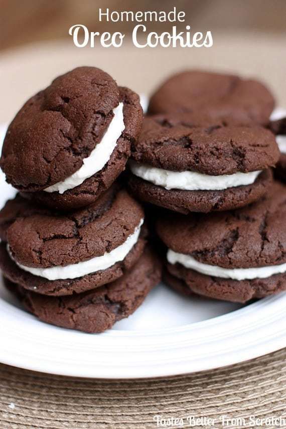 Homemade Oreo cookies stacked on a white plate, featuring chocolate cookies with cream filling.