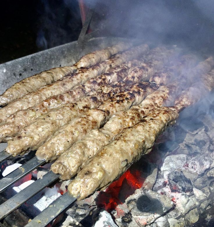 Grilled kebabs sizzling over hot charcoal on skewers, surrounded by smokey goodness, perfect for a delightful barbecue.