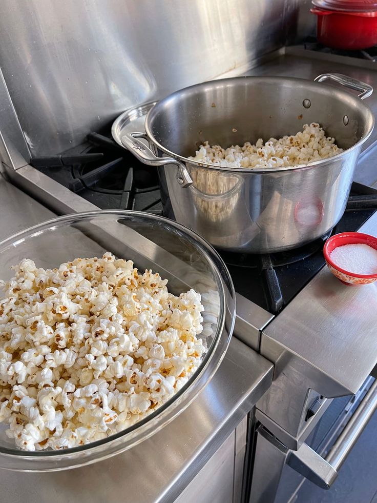Stovetop popcorn freshly made in a pot, served in a bowl with salt on the side.