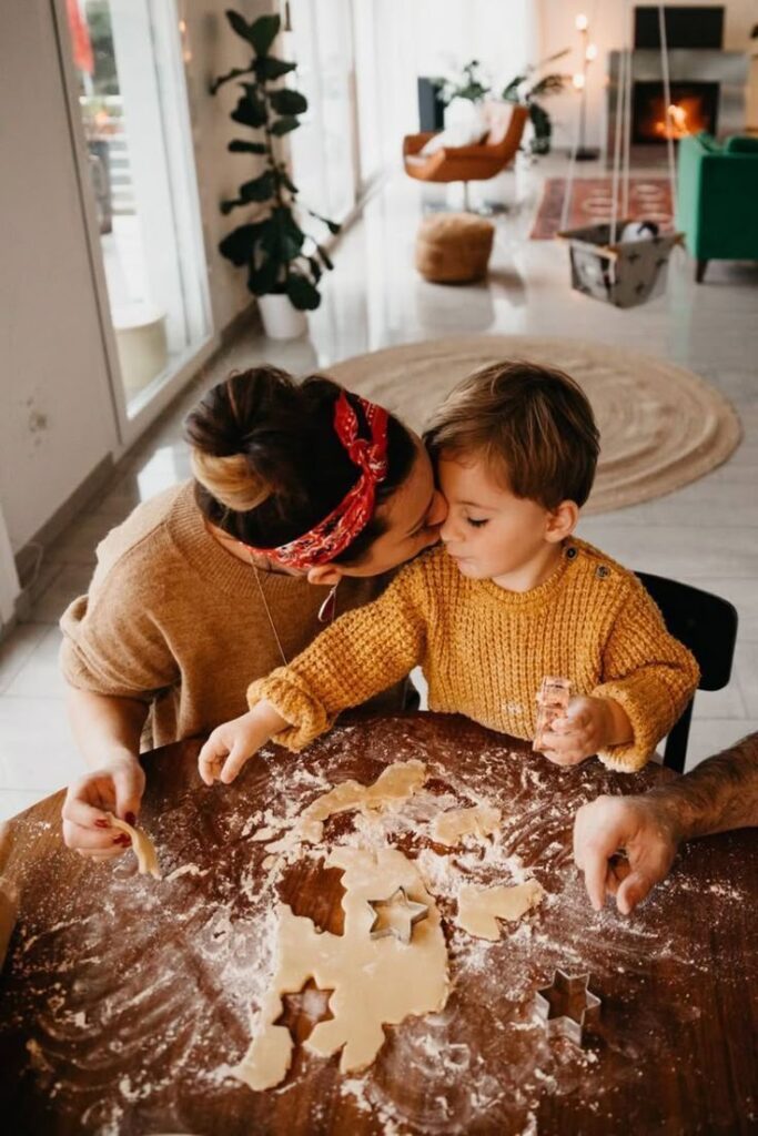 Mother and child making cookies together in a cozy kitchen setting.