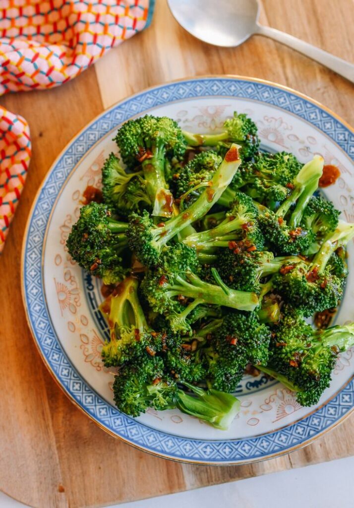 Fresh steamed broccoli with garlic and soy sauce on a decorative plate. Healthy, delicious side dish.
