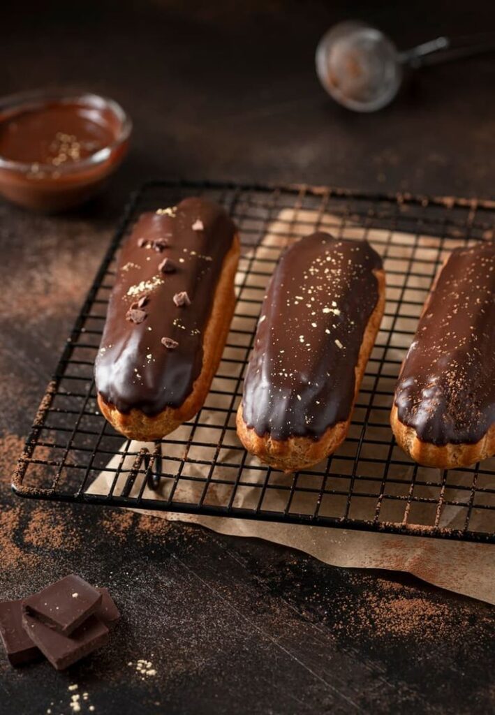 Delicious chocolate eclairs on a wire rack with a dark chocolate glaze. Perfect dessert for chocolate lovers.