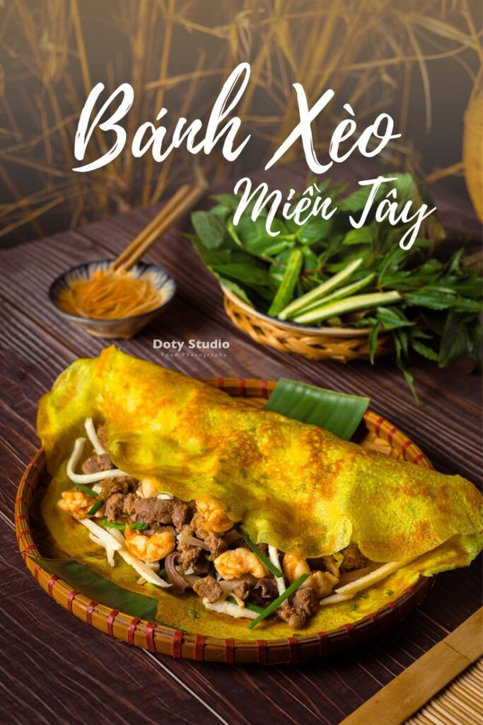 Vietnamese Bánh Xèo Miền Tây pancake with shrimp and vegetables on a woven platter, garnished with herbs.