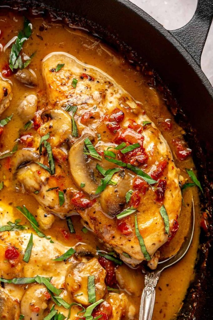 Marry Me Chicken - Marry Me Chicken : Easy, Creamy, and Delicious Meal Creamy Tuscan chicken with mushrooms and sun-dried tomatoes in a skillet, garnished with fresh basil leaves.