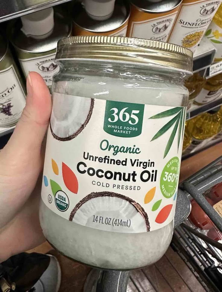 Jar of 365 Organic Unrefined Virgin Coconut Oil, 14 fl oz, on a store shelf, Whole Foods label visible.