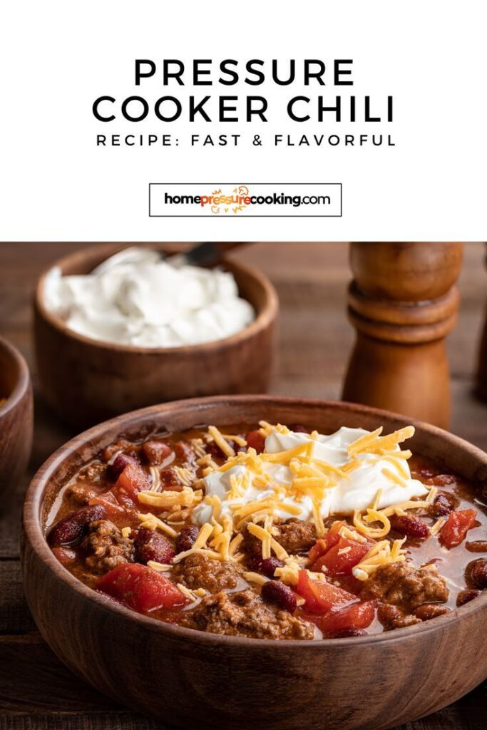 Bowl of pressure cooker chili topped with cheese and sour cream, with side dishes in the background.