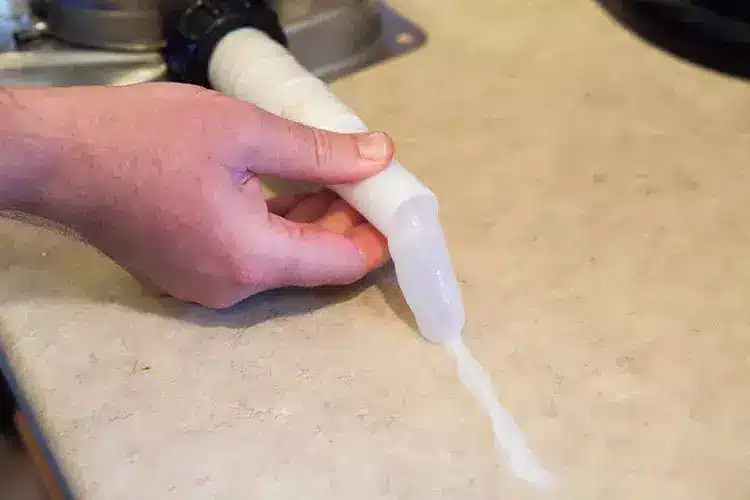 Hand removing old wax buildup from kitchen countertop surface.