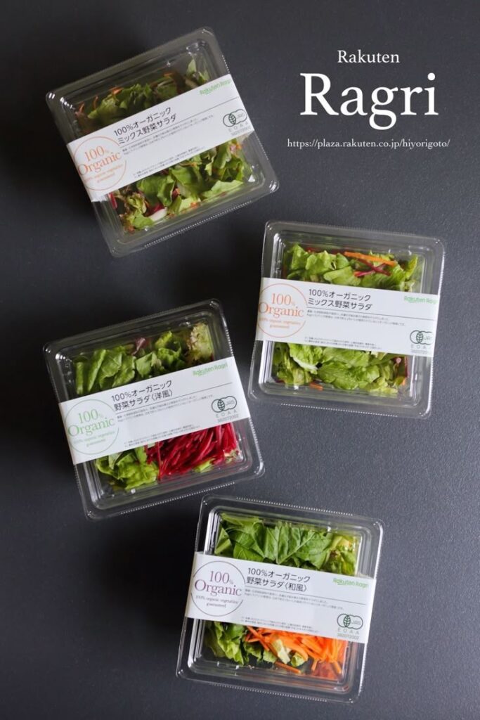Four packs of Ragri 100% organic salads in plastic containers on a dark background.