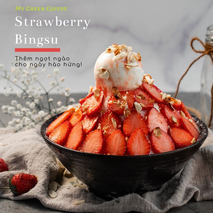 Delicious strawberry bingsu topped with nuts and ice cream in a black bowl, perfect for a refreshing treat.
