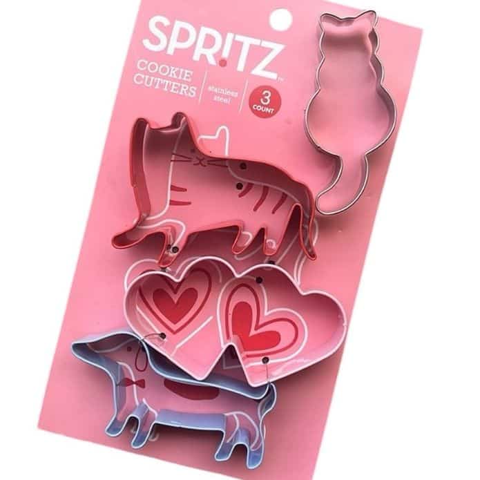 Cat, dog, and heart-shaped stainless steel cookie cutters by Spritz on pink packaging.
