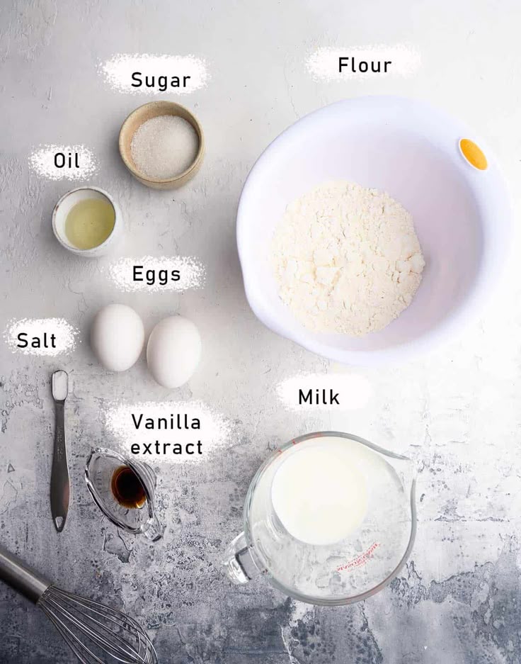 Baking ingredients on a table: flour, sugar, eggs, milk, oil, vanilla extract, salt. Ready for a cake recipe!