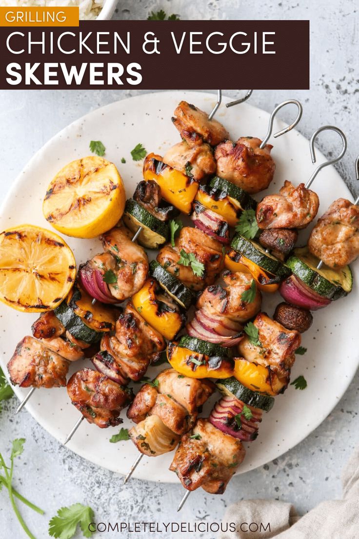 Grilled chicken and vegetable skewers on a plate with lemon halves, perfect for a summer barbecue.