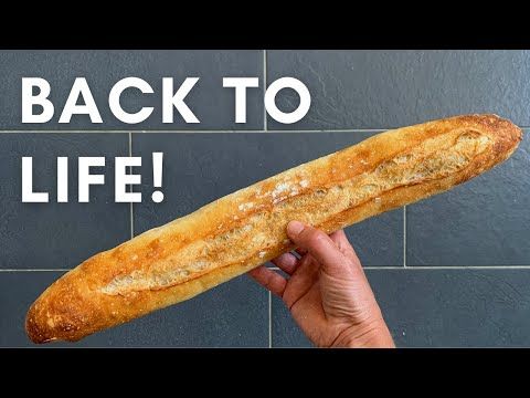 Hand holding a freshly baked baguette with text Back to Life! on a tiled background.