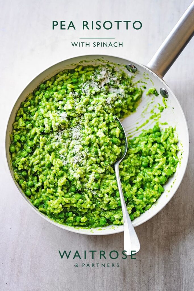 Pea and spinach risotto in a pan with spoon, topped with cheese, from Waitrose & Partners.