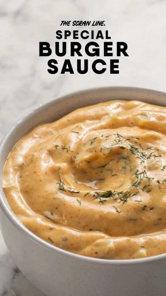 Creamy homemade burger sauce in a bowl, garnished with fresh herbs, perfect condiment for burgers.