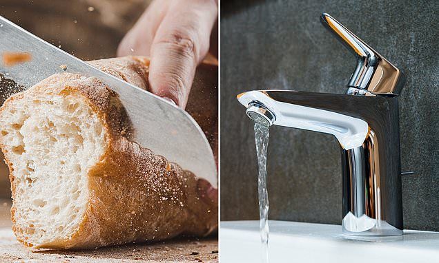 Cutting fresh bread beside running water from a modern faucet in a kitchen setting.