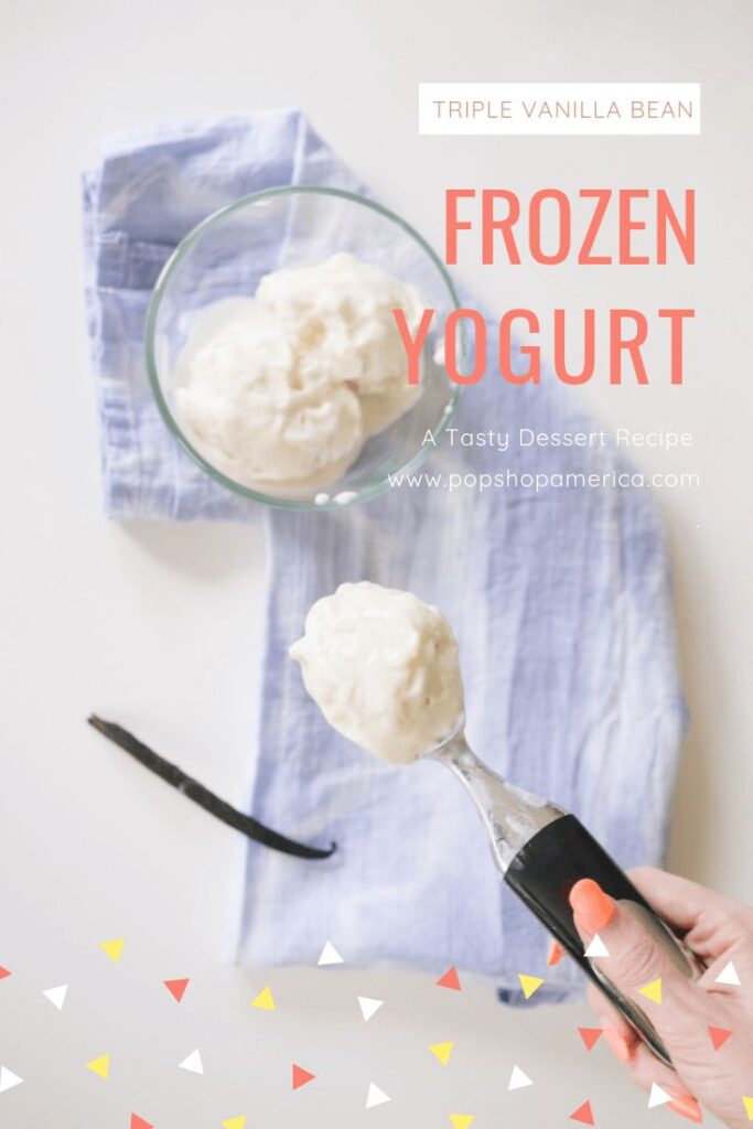 Triple vanilla bean frozen yogurt in a bowl with an ice cream scoop and vanilla pod on a blue cloth.