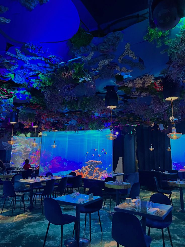 Underwater-themed restaurant interior with vibrant blue lighting and marine decor.