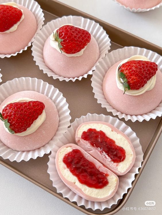 Strawberry daifuku on a tray, topped with fresh strawberries and cream, showcasing a sweet treat with vibrant colors.