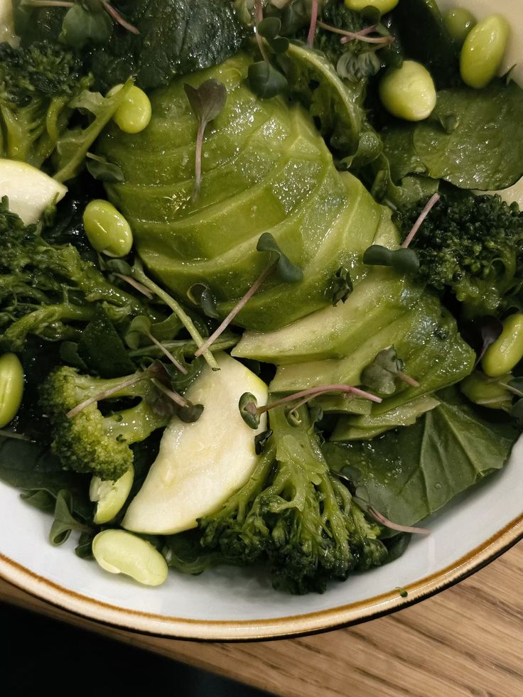 Fresh green salad bowl with avocado, broccoli, edamame, and leafy greens, perfect for a healthy, nutritious meal.