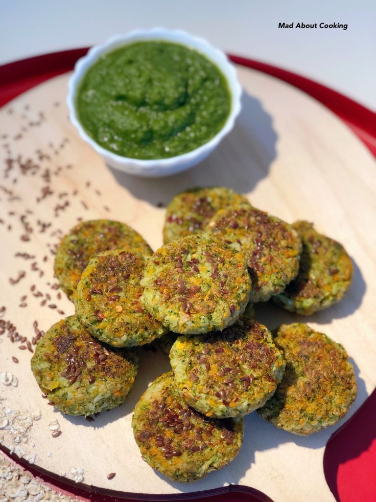Healthy homemade falafel patties with green chutney on a wooden board, topped with flax seeds.