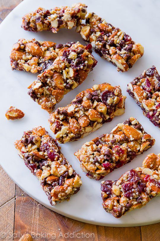 Homemade granola bars with almonds, cranberries, and chocolate chips on a marble surface. Perfect healthy snack.