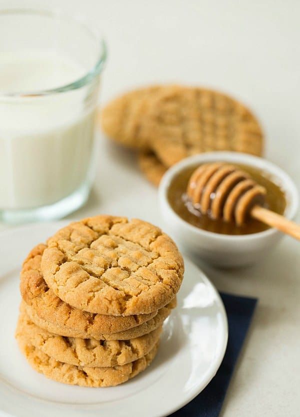 Stack of peanut butter cookies with milk and honey dip. Perfect snack pairing.