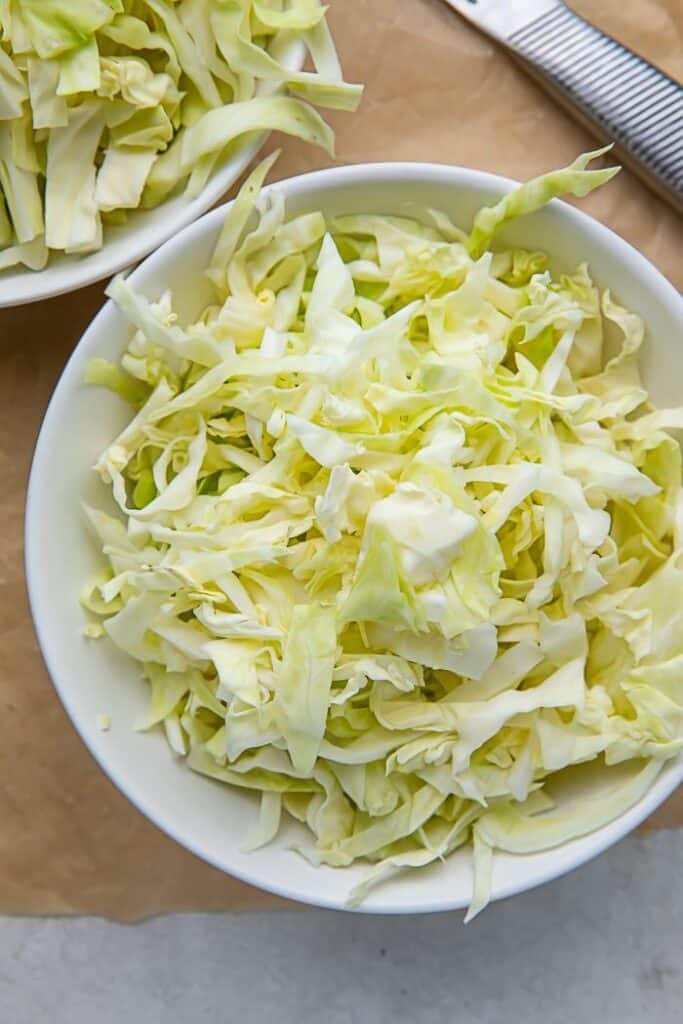 Bowl of freshly sliced cabbage, ideal for salads and healthy recipes.
