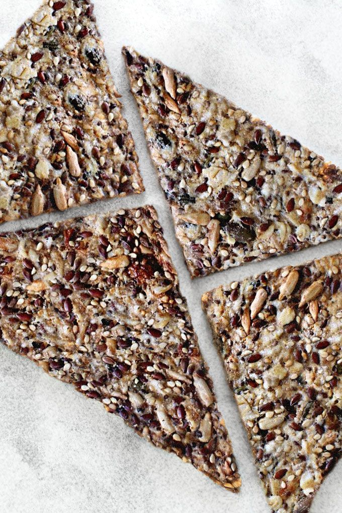 Crunchy seed crackers with mixed grains and seeds on a light surface, showcasing a healthy snack option.