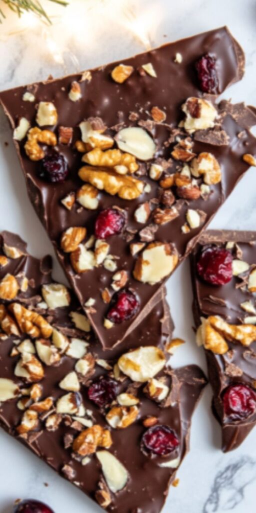 Chocolate bark with nuts and dried cranberries, topped with assorted nuts. Perfect holiday treat or gift idea.