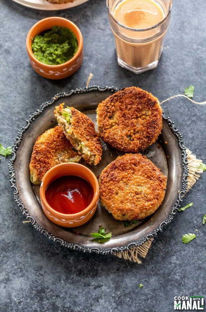 Vegetable cutlets served with chutney, ketchup, and chai on a rustic plate, perfect for a cozy Indian snack time.