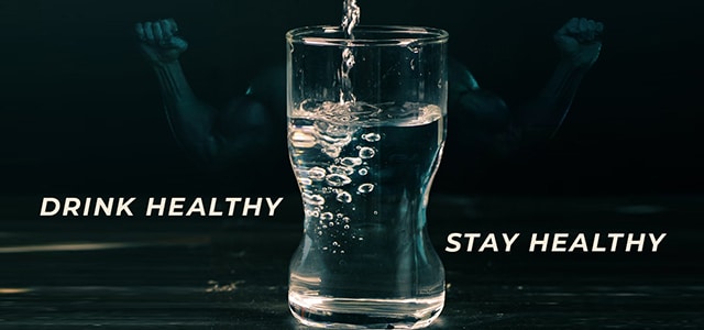 Glass of water with text Drink Healthy, Stay Healthy and an image of flexed arms in the background.