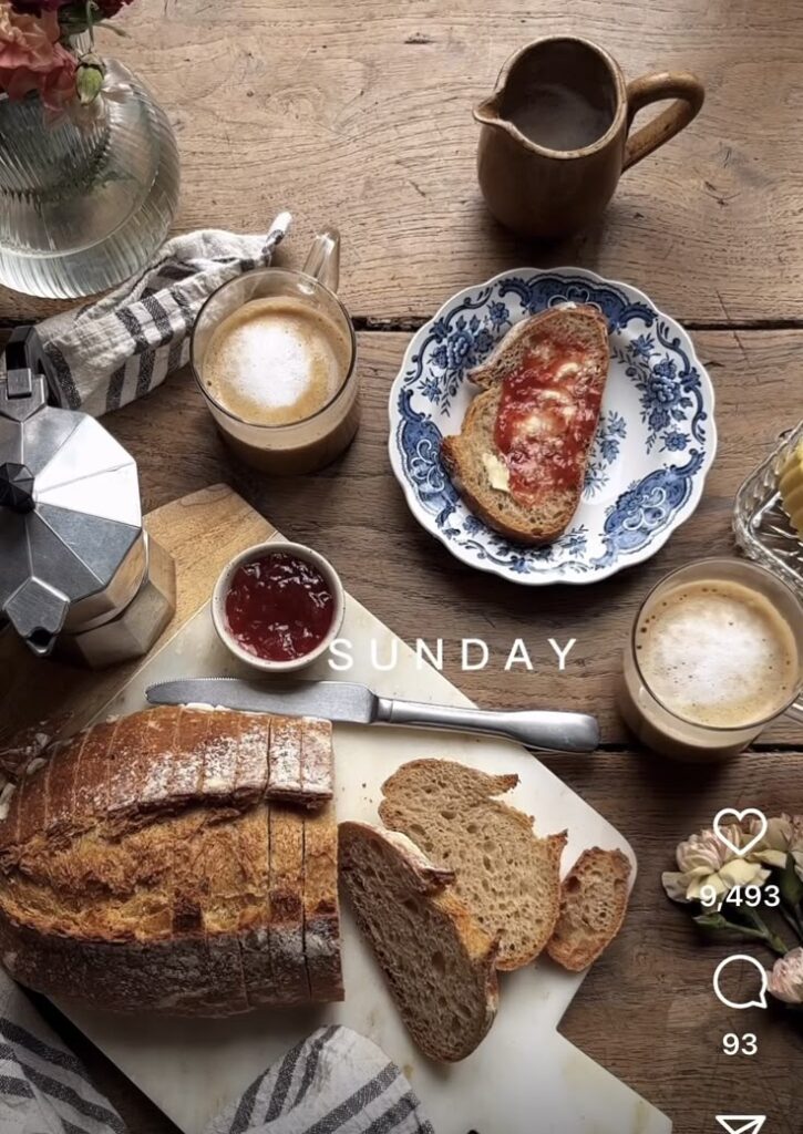 Cozy Sunday breakfast with artisan bread, jam, and coffee on rustic wooden table.