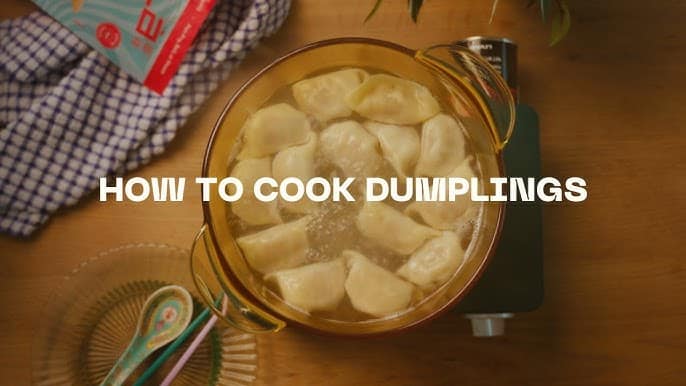 Boiling dumplings in a glass pot with text overlay: How to Cook Dumplings on a wooden kitchen countertop.