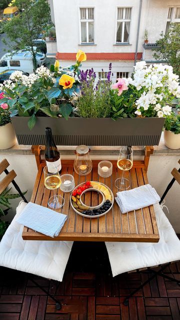 Cozy patio table set with wine, fruit, and flowers, perfect for a relaxing outdoor brunch.