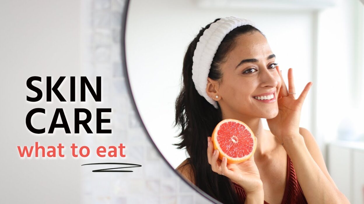Woman in mirror enjoying skincare with a grapefruit, highlighting the importance of diet for healthy skin.