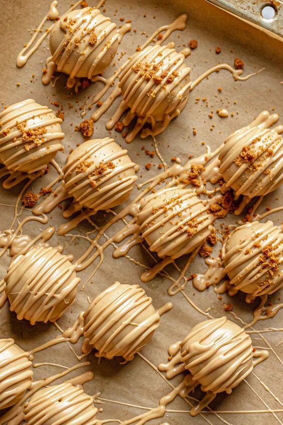 Delicious peanut butter truffles drizzled with caramel, arranged on parchment paper for a tasty treat.