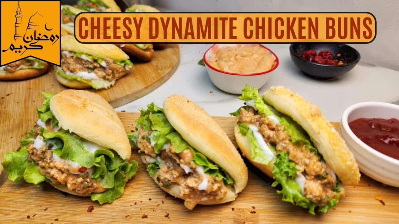 Cheesy dynamite chicken buns with lettuce on a wooden board, accompanied by dipping sauces. Perfect Ramadan treat!